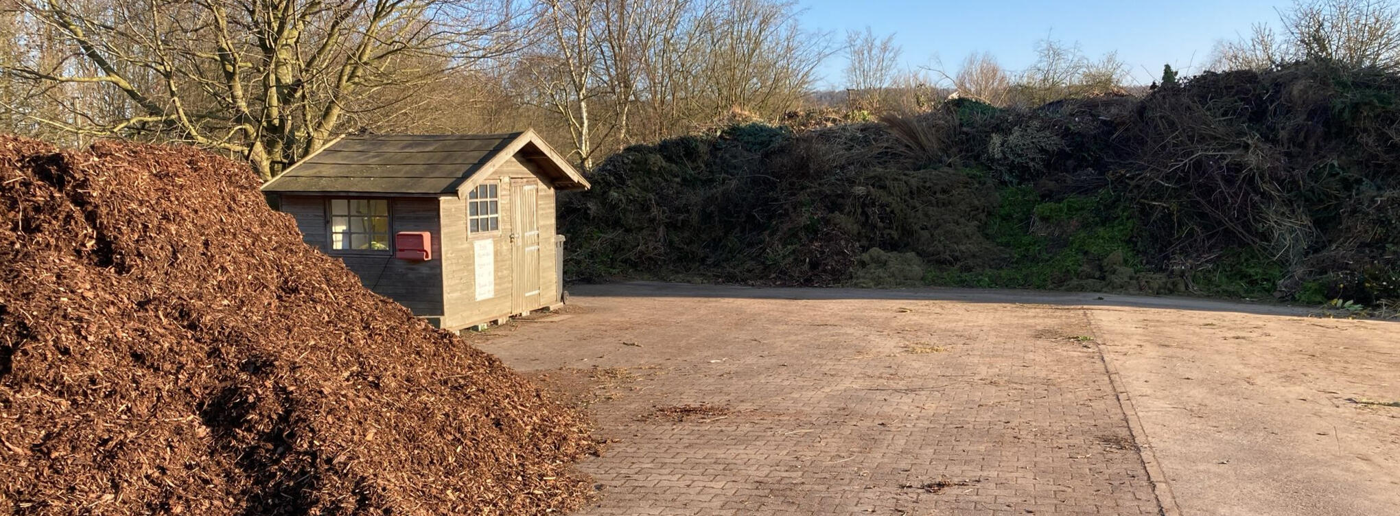 Komposthaufen und Holzhütte